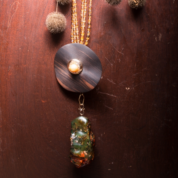 ART.18 - Citrine and ebony necklace. Central part in ebony with removable ring in hammered yellow gold with Australian pearl, yellow and orange sapphire. Green amber pendant